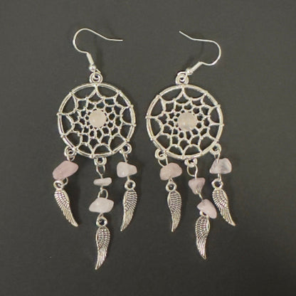 Pair dreamcatcher earrings with feathers and stones on a dark background