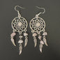 Pair dreamcatcher earrings with feathers and stones on a dark background