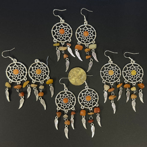 Set of dreamcatcher earrings with colorful beads on a dark background